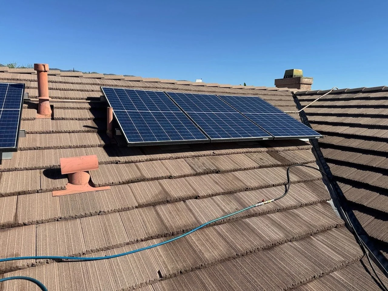 A rooftop array with cleaning hose